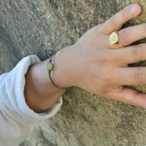 Bracelet en cuir et péridot, porté au poignet.