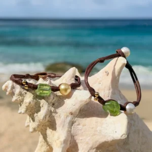 Bracelet en cuir, péridot et perle au choix, sur un coquillage, plusieurs modèles visibles.