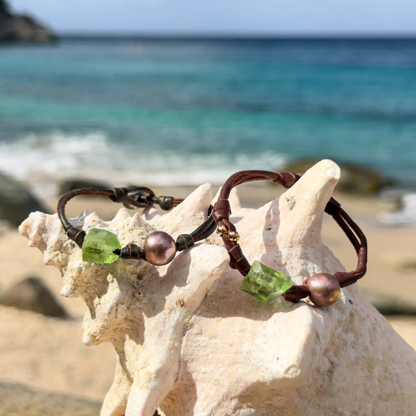 Bracelet en cuir, péridot et perle au choix, sur un coquillage, plusieurs modèles visibles.