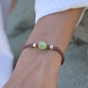 Bracelet en cuir tressé, péridot et tubes plaqués or, porté au poignet. Vue 2.