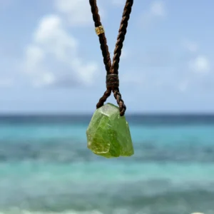 Braided leather necklace with a peridot pendant, hanging freely.