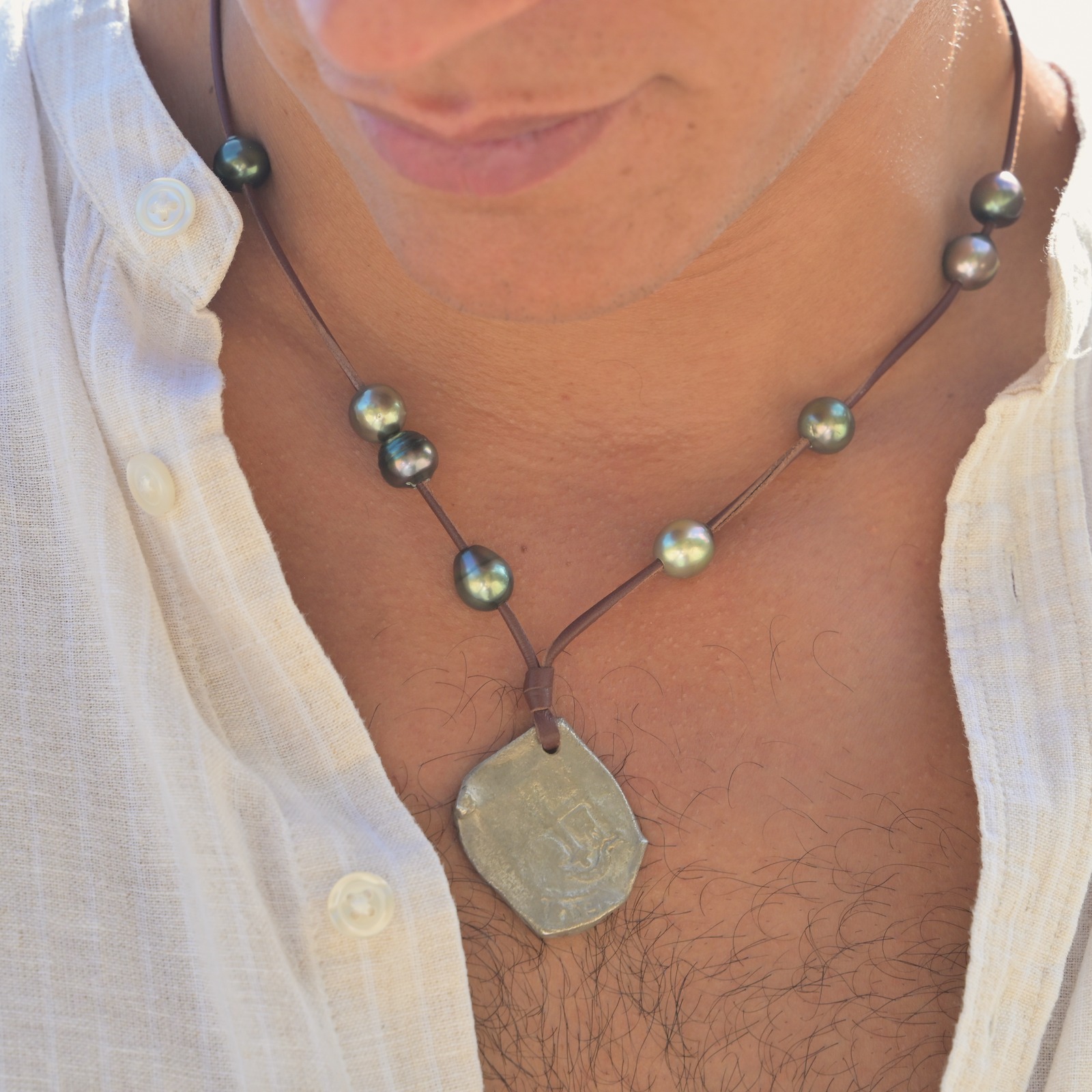 Pendant necklace with an eight-reales coin and Tahitian pearls, close-up on the model.
