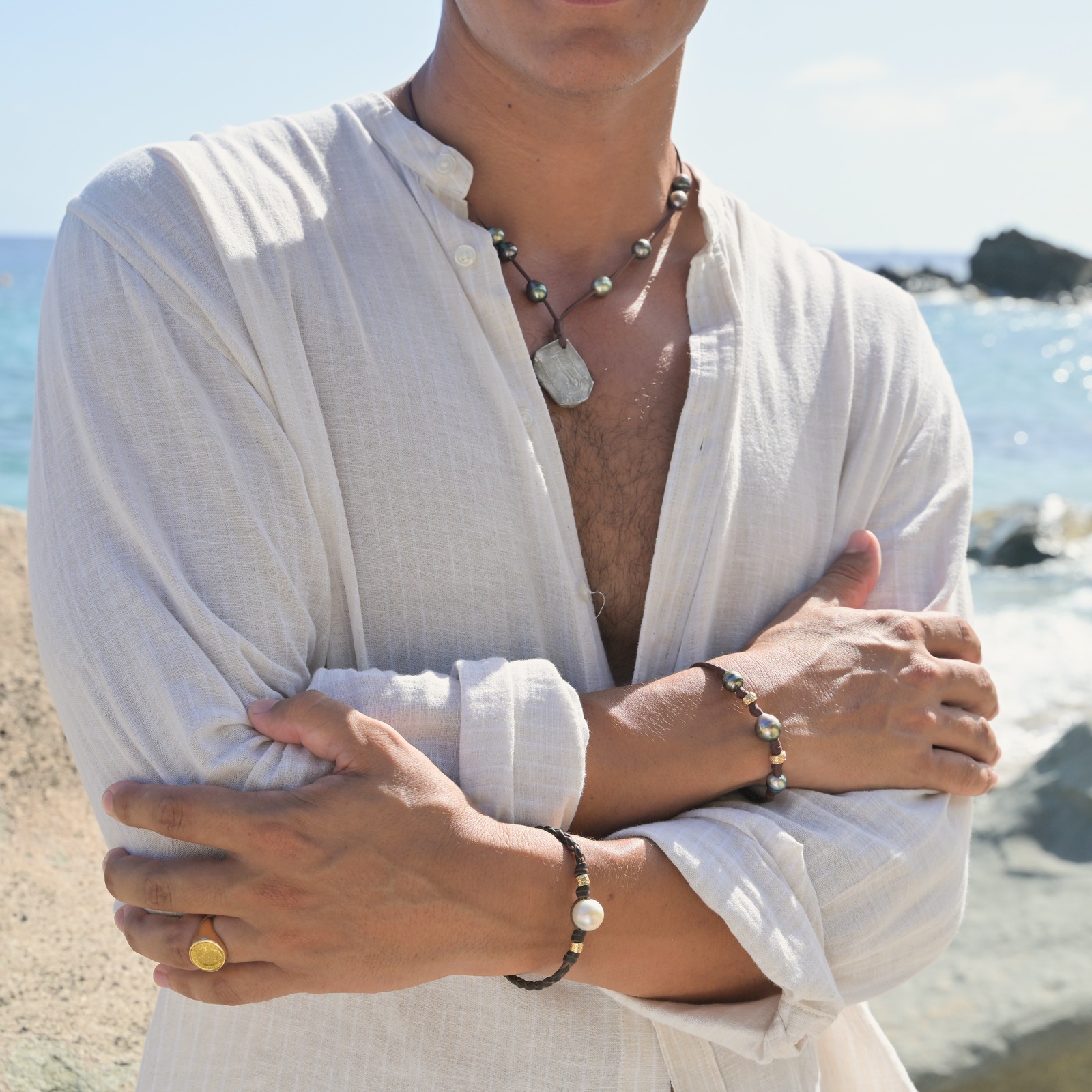 Pendant necklace with an eight-reales coin and Tahitian pearls, worn view.
