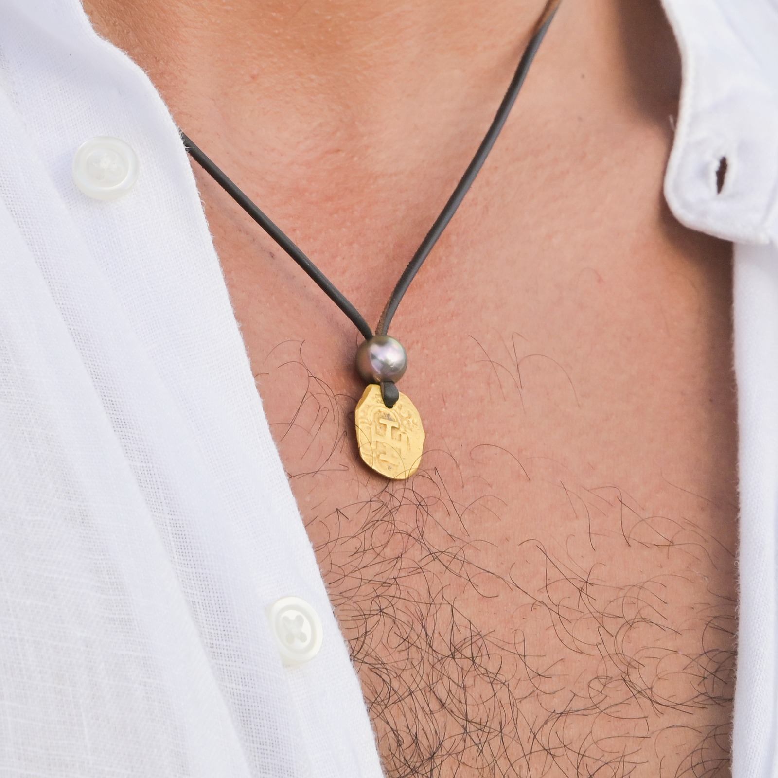 Gold Through the Centuries, an antique escudo necklace with a Tahitian pearl, close-up on the model.