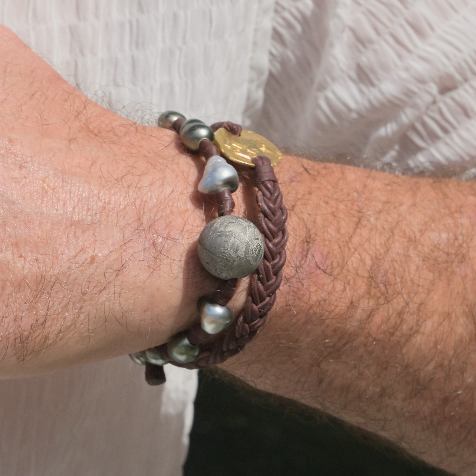 Bracelet en cuir tressé et monnaie de 2 escudos en or, détail du bracelet tressé.