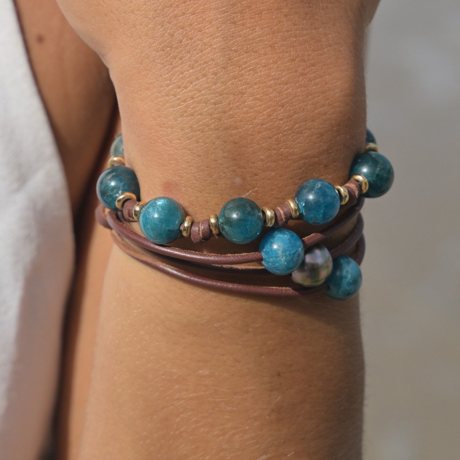Bracelet en cuir, rang d’apatites et anneaux dorés porté