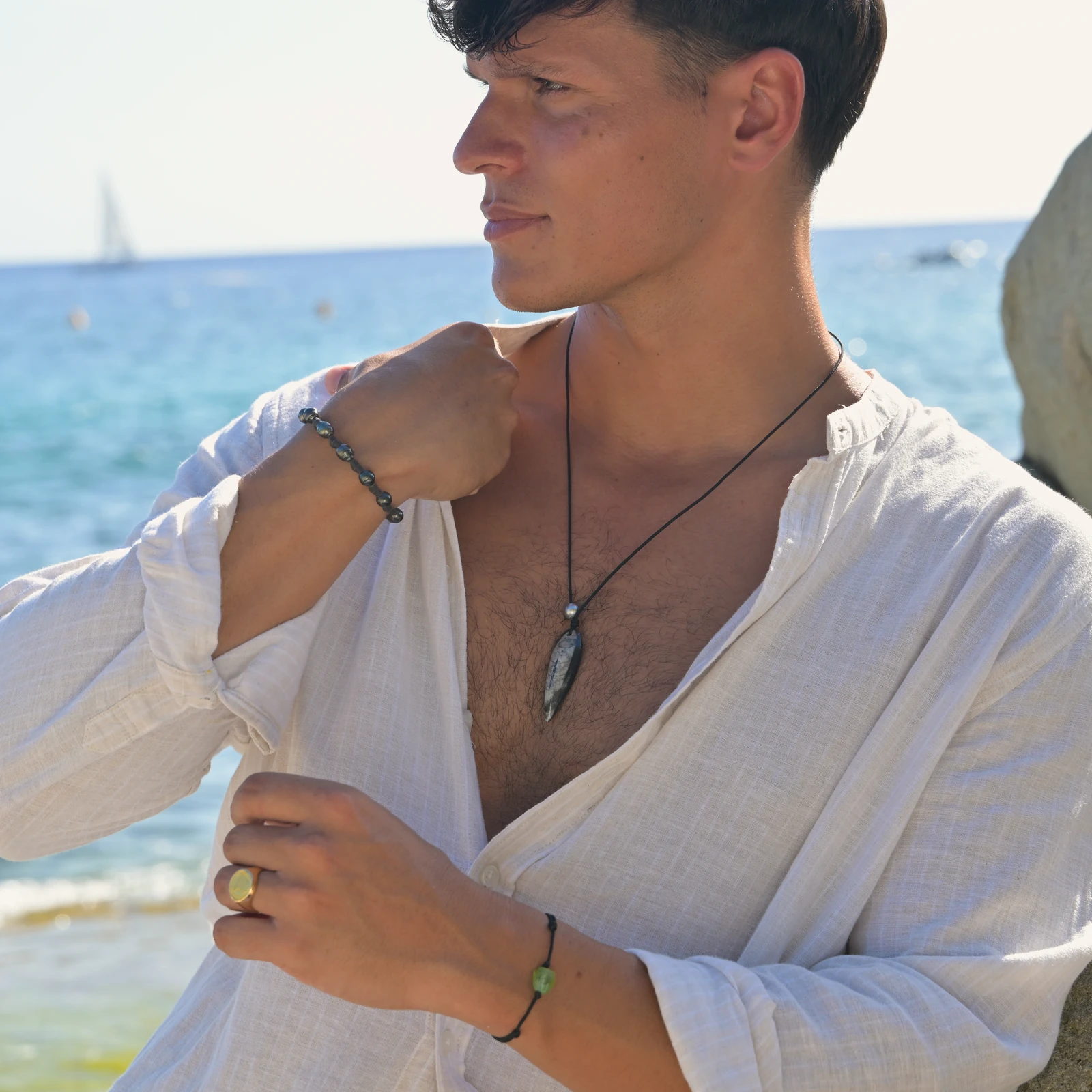 Unisex Leather Bracelet with Tahitian Pearls and Knots, worn on the wrist.