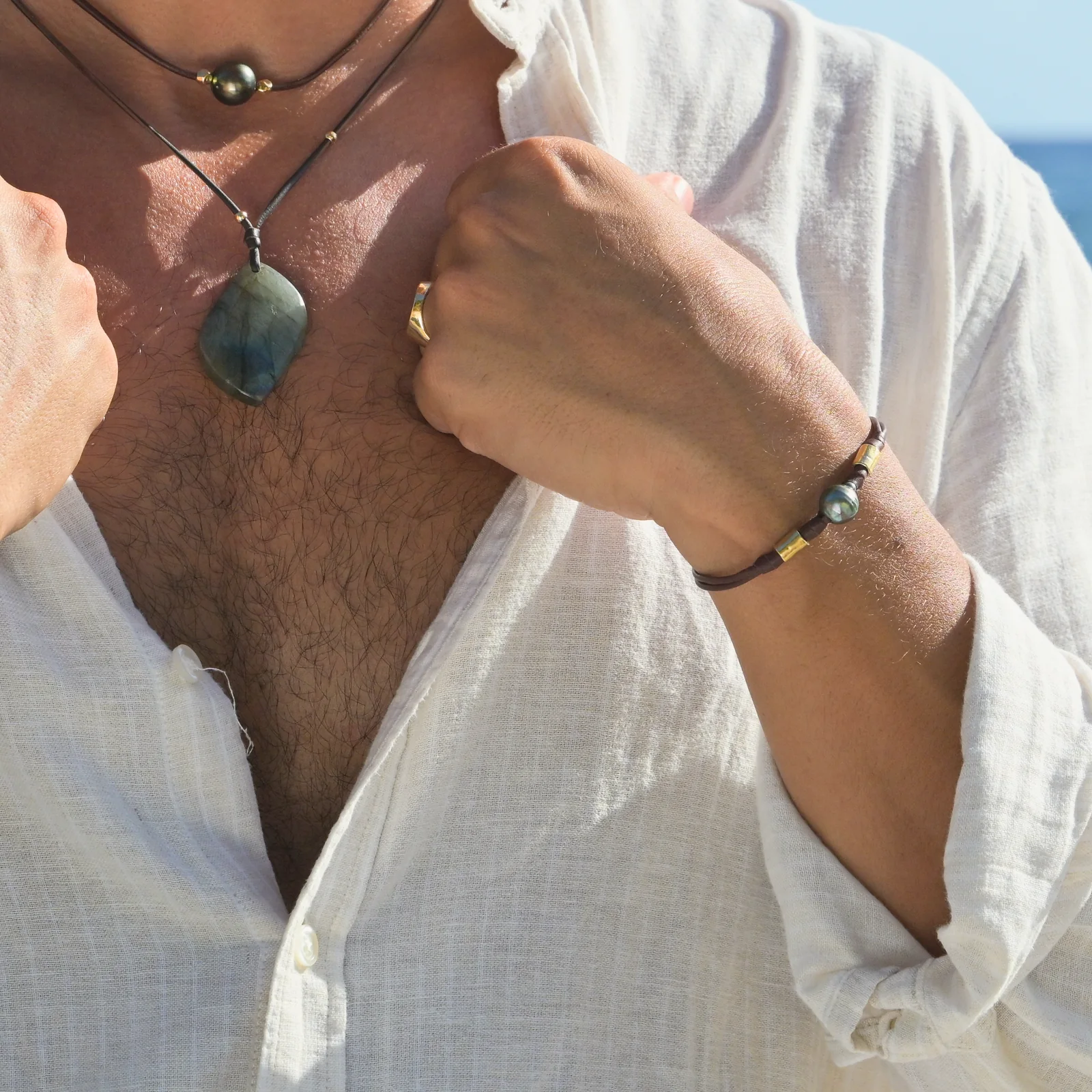 Double Leather Bracelet with a Tahitian Pearl and Gold-Plated Tubes, worn on the wrist.