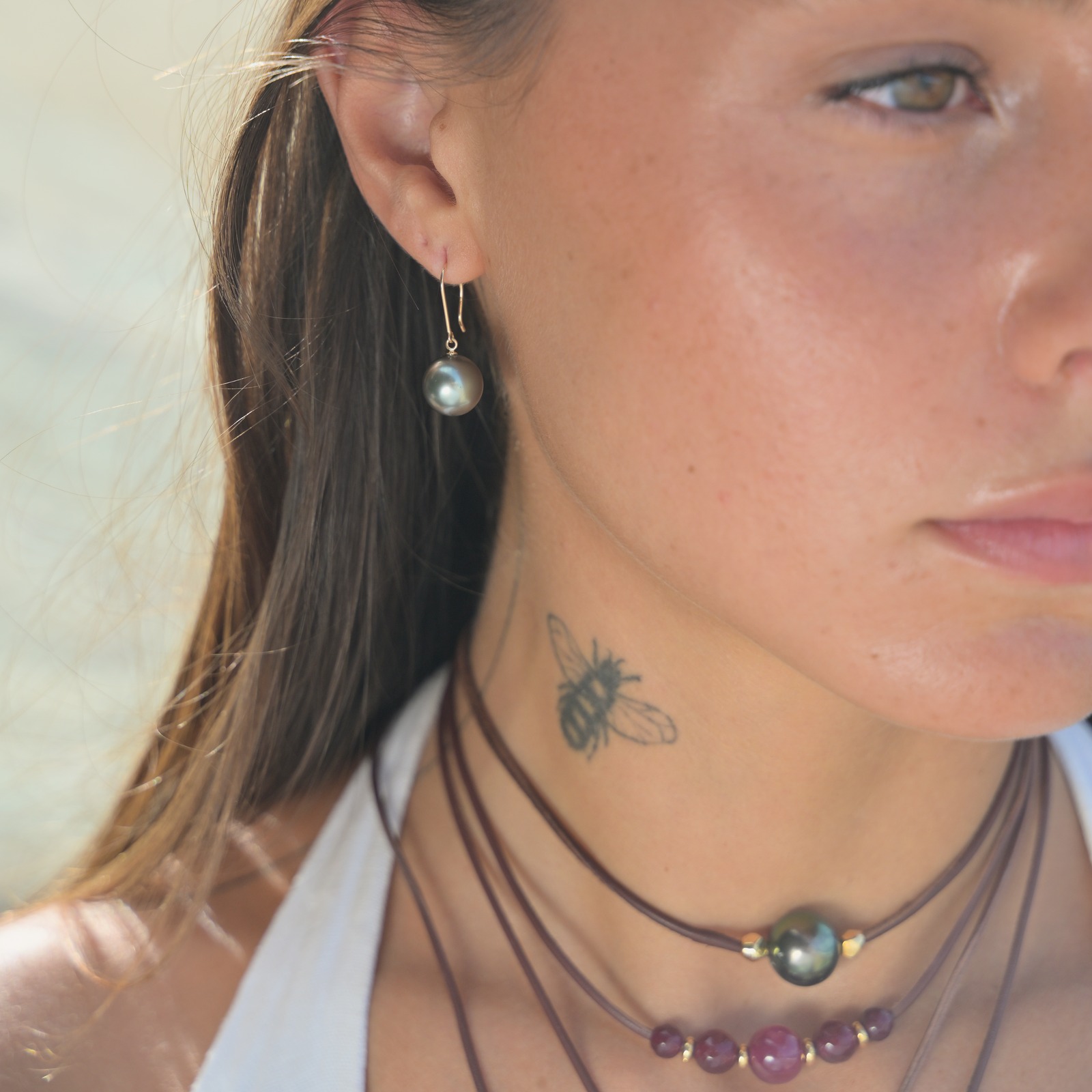 Collier ras du cou en cuir, cinq rubis et anneaux dorés, porté au cou