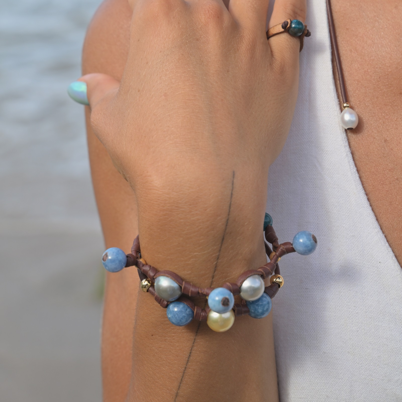 Bracelet en cuir perles de Tahiti et apatites pendantes, porté au poignet