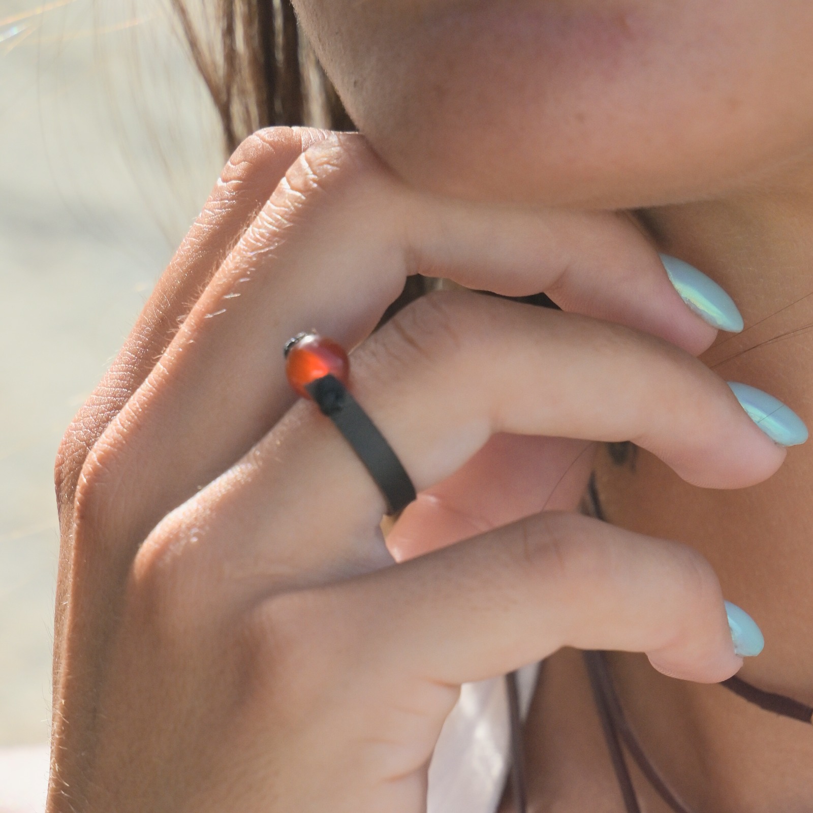 Bague en cuir et cornaline, portée à la main