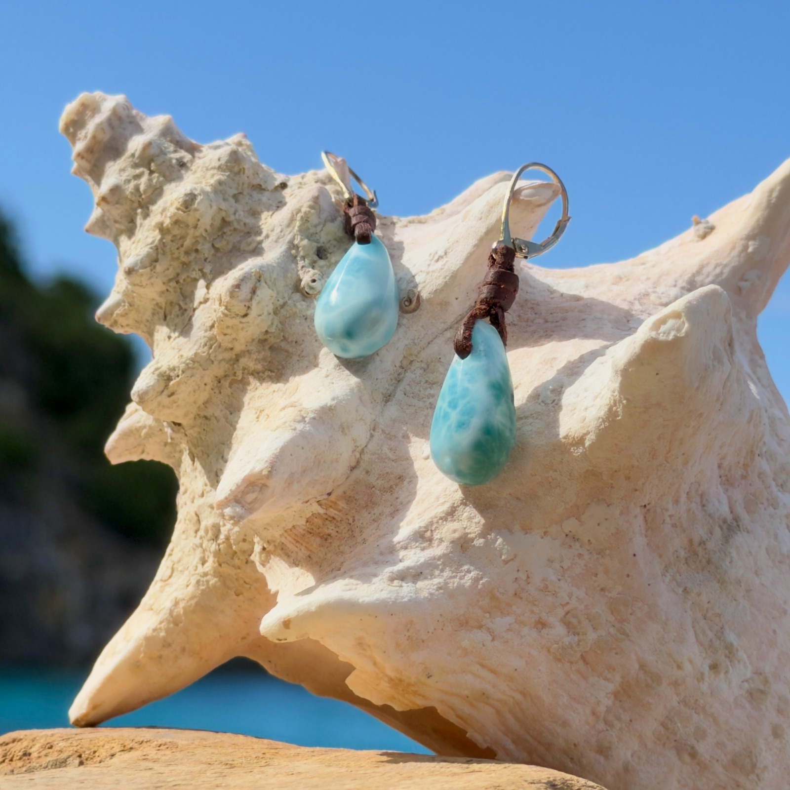 Boucles d’oreilles en cuir et gouttes de Larimar, posé en ambiance naturelle