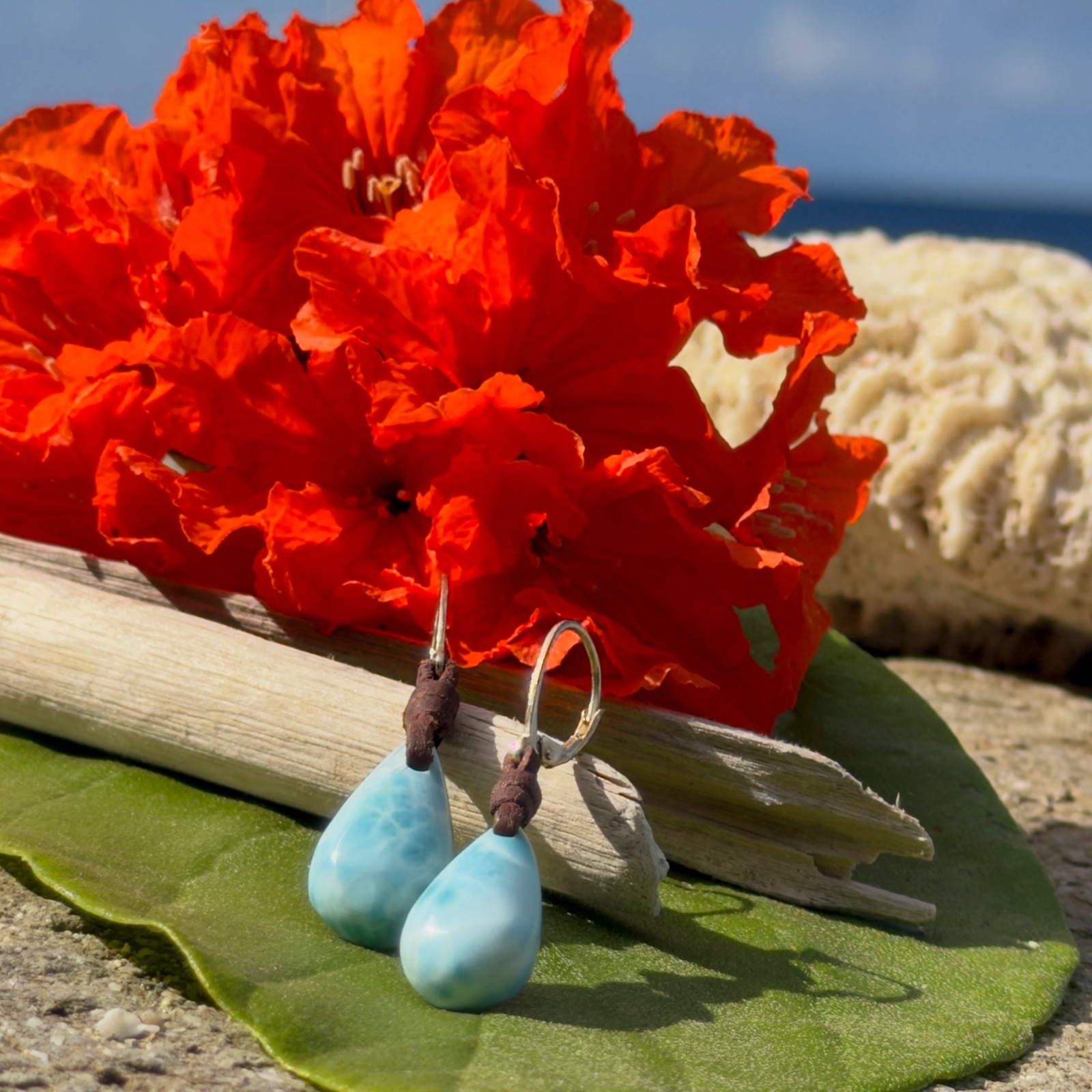 Boucles d’oreilles en cuir et gouttes de Larimar, posé en ambiance naturelle
