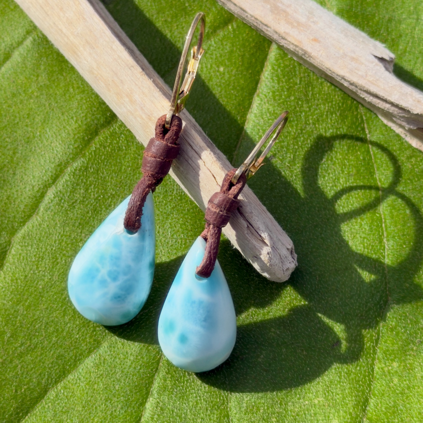 Boucles d’oreilles en cuir et gouttes de Larimar, posé en ambiance naturelle