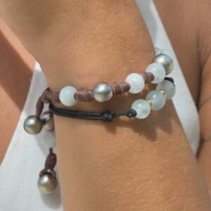 Bracelet en cuir noué, aigues-marines et perles de Tahiti, porté au poignet