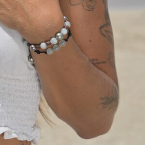 Bracelet en cuir noué, aigues-marines et perles de Tahiti, porté au poignet