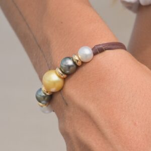 Bracelet en cuir, perles multicolores et anneaux dorés, porté au poignet