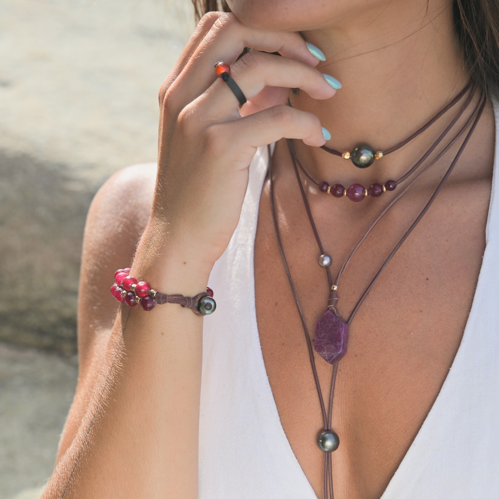 Bracelet double rang en cuir, rubis facettés et tubes dorés, porté au poignet