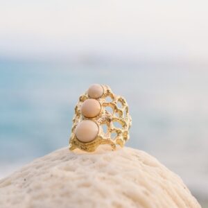 Bague Corail en or et trio de perles de Lambi, présentation en ambiance naturelle
