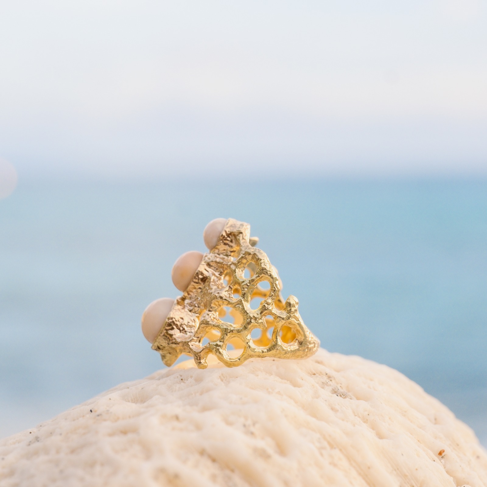 Bague Corail en or et trio de perles de Lambi, présentation en ambiance naturelle