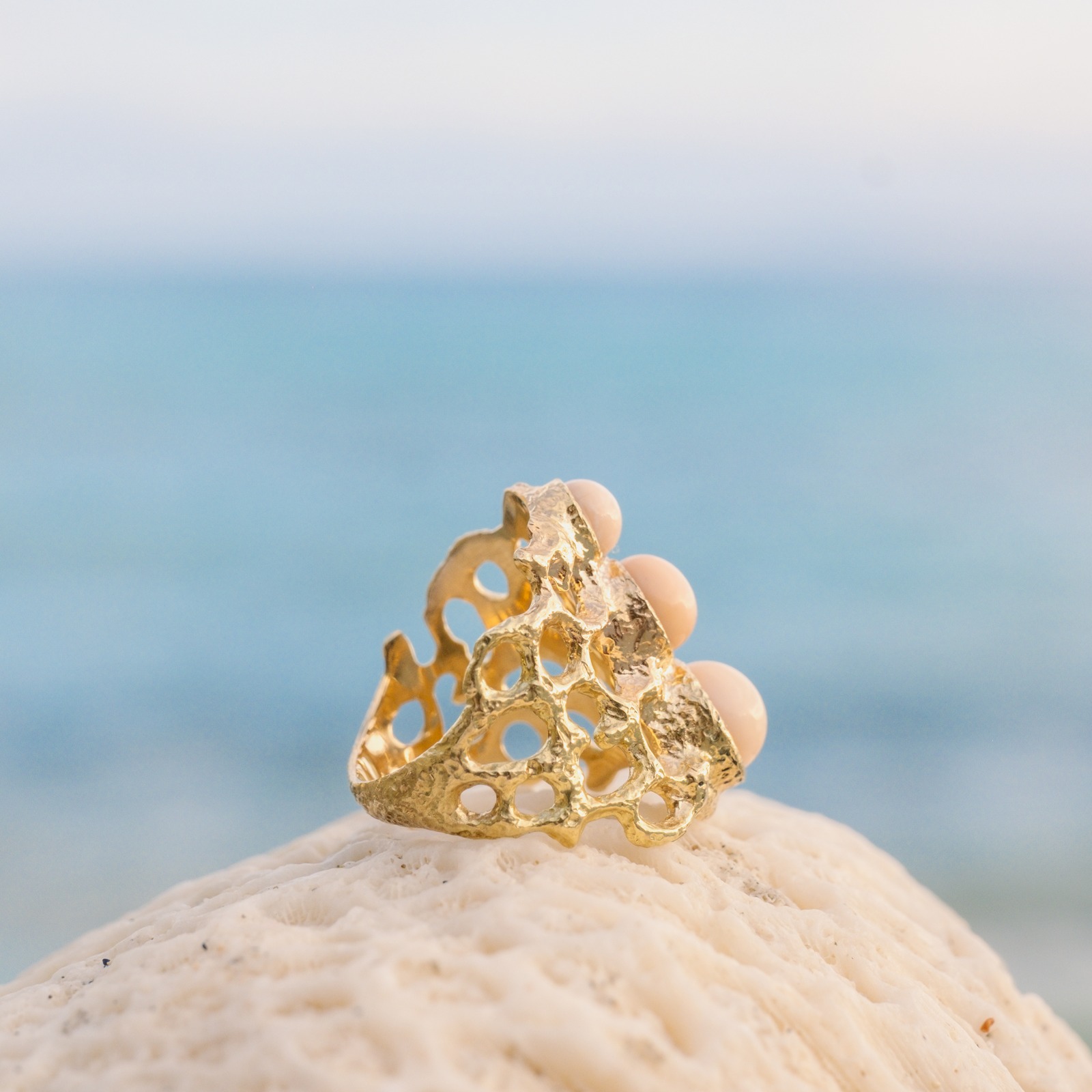 Bague Corail en or et trio de perles de Lambi, présentation en ambiance naturelle