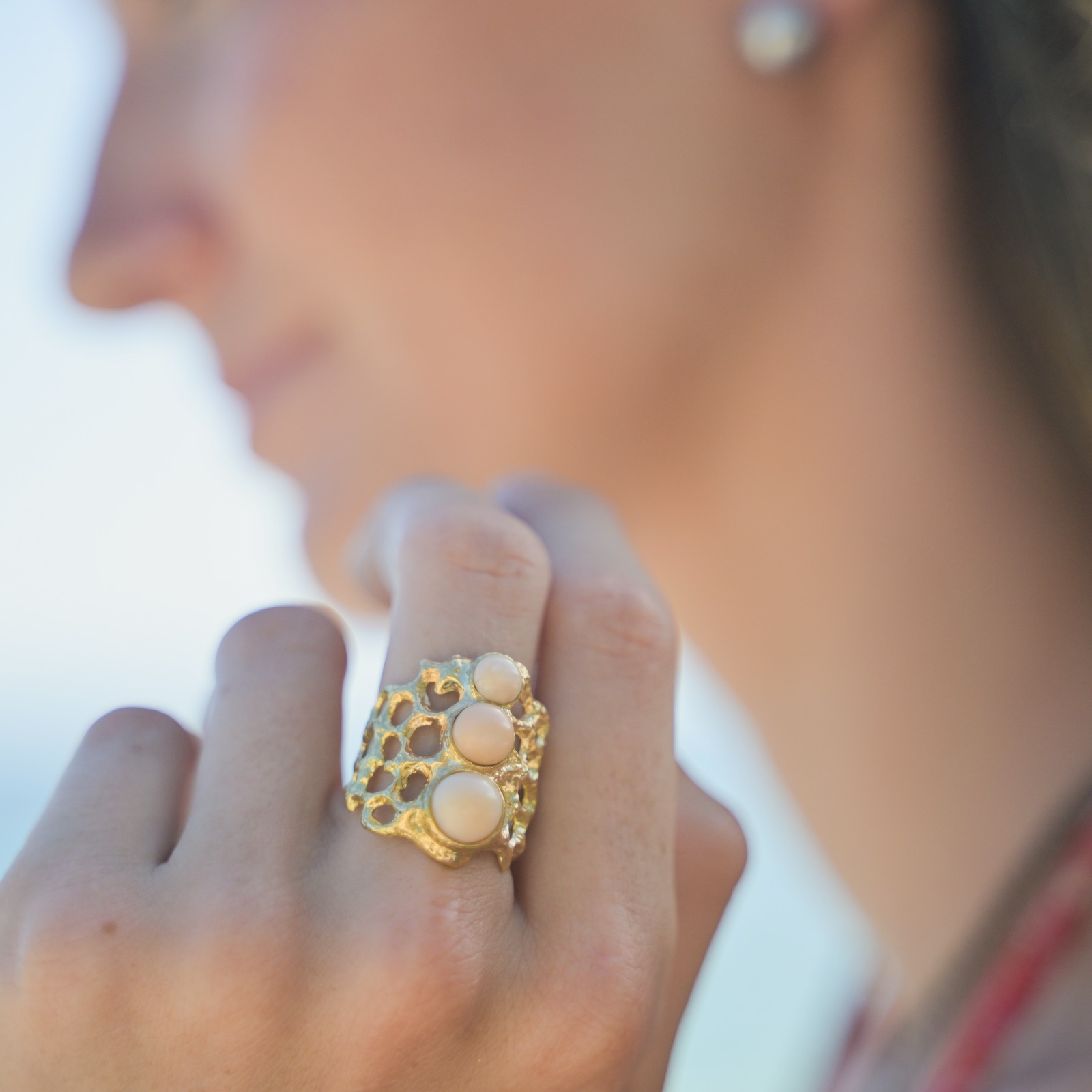 Bague Corail en or et trio de perles de Lambi, présentation en ambiance naturelle