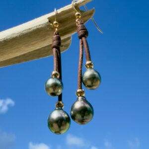 Boucles d’oreilles doubles pendantes en cuir et perles de Tahiti, présentation en ambiance naturelle