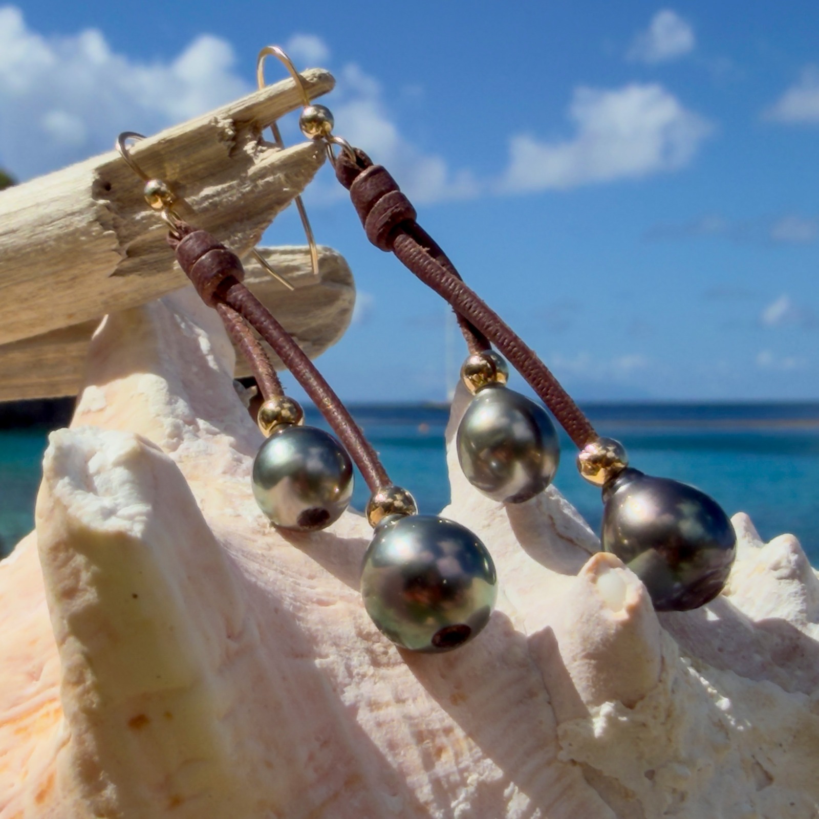 Boucles d’oreilles doubles pendantes en cuir et perles de Tahiti, présentation en ambiance naturelle