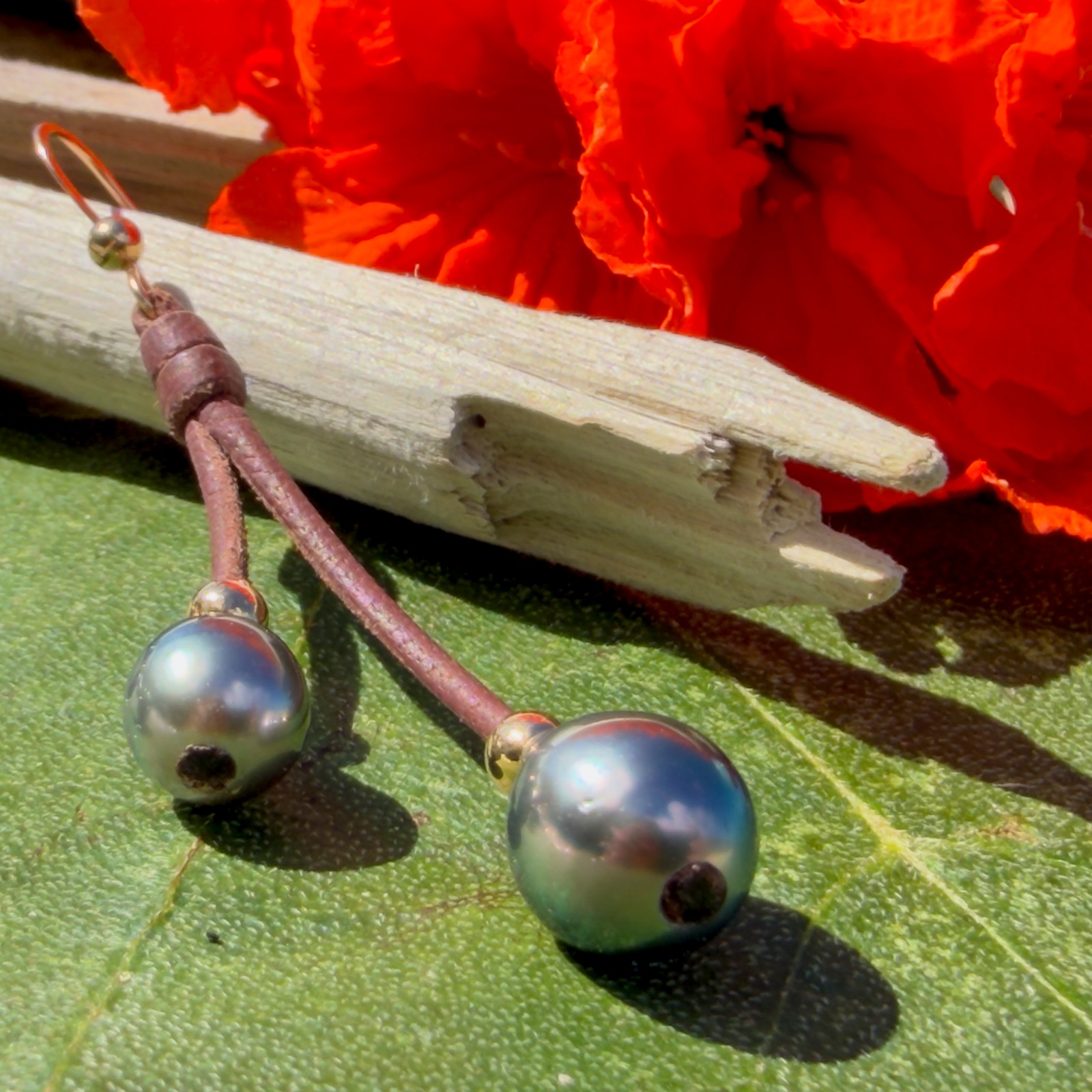 Boucles d’oreilles doubles pendantes en cuir et perles de Tahiti, présentation en ambiance naturelle
