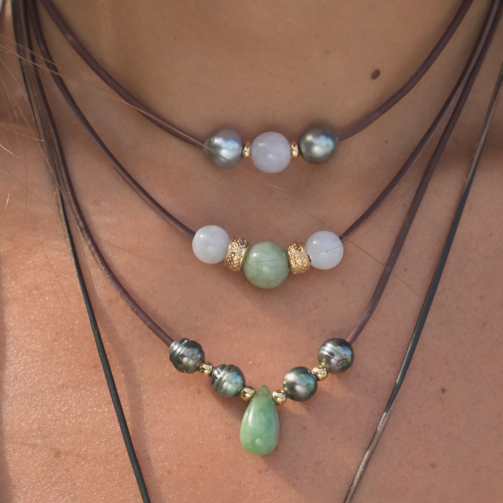 Leather choker with a trio of jade stones, worn at the neckline