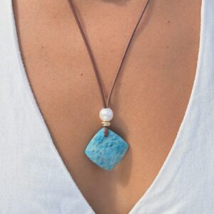 Collier en cuir, pendentif apatite et perle blanche, porté au cou