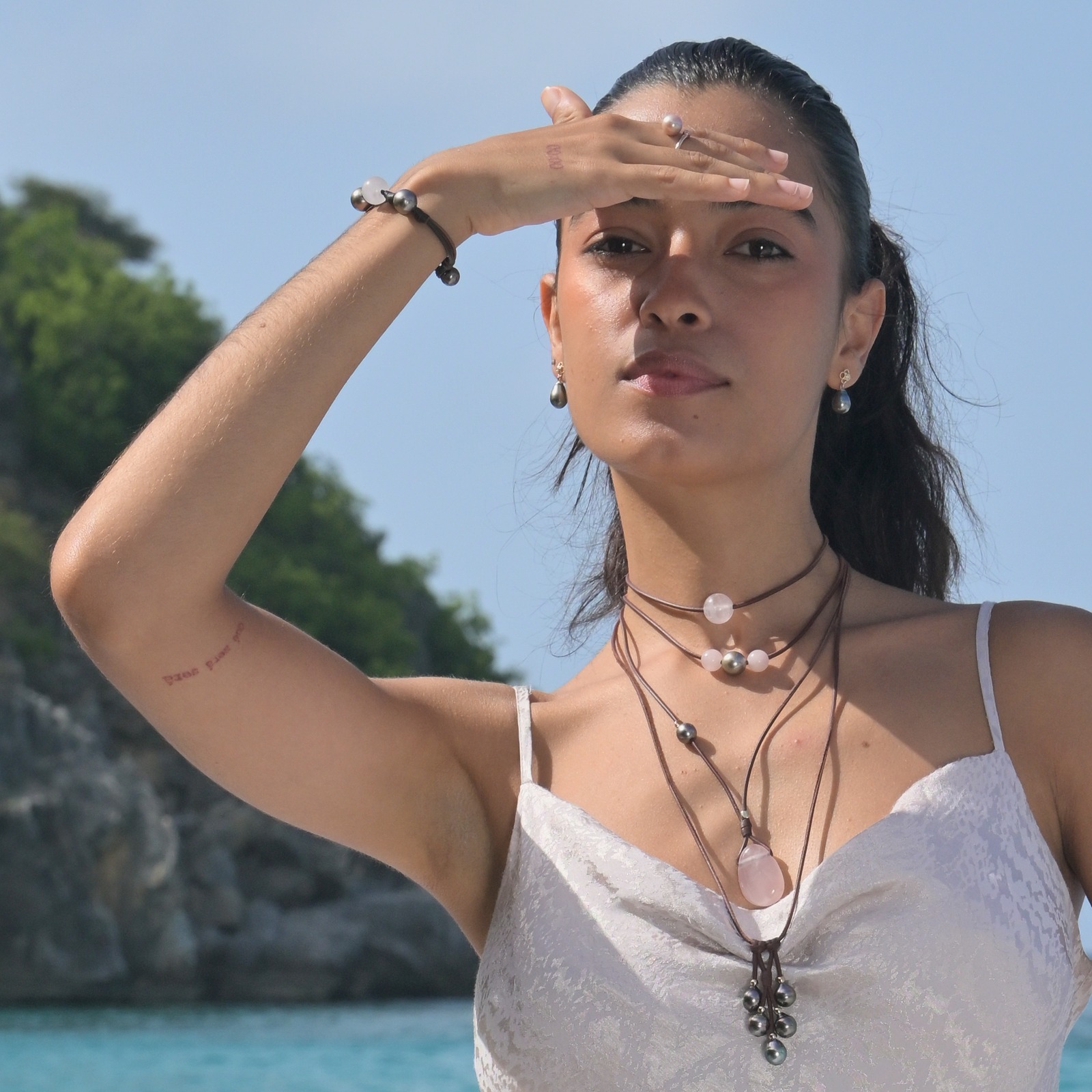 Leather bracelet with rose quartz between two Tahitian pearls, styling portrait with several pieces of jewelry