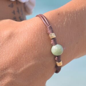 Bracelet en cuir, jade et tubes dorés, porté au poignet
