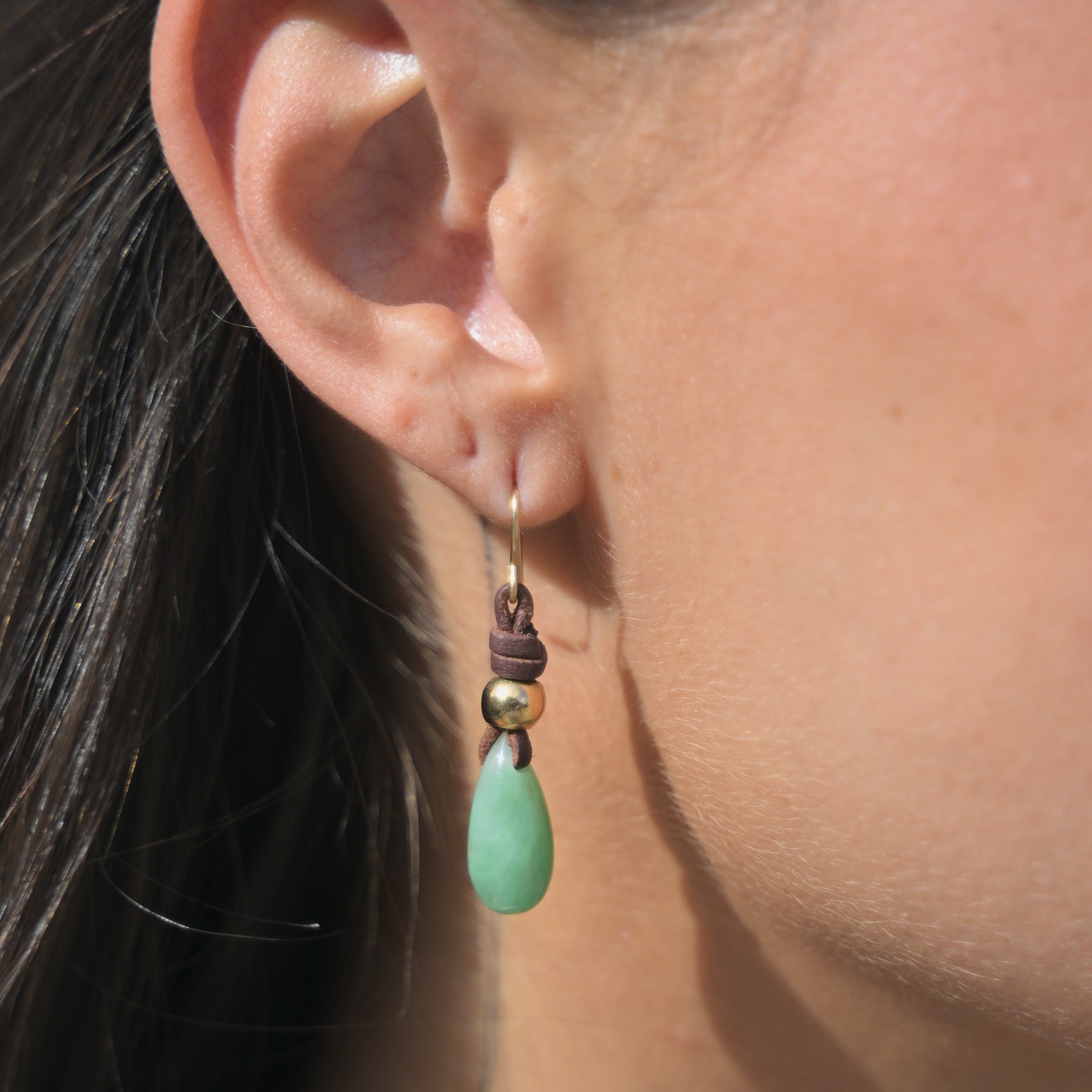 Boucles d’oreilles en cuir et gouttes de jade, portées aux oreilles