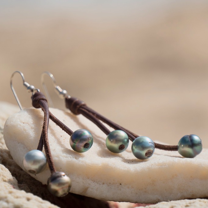 Leather earrings with six Tahitian pearls, in a natural still-life setting
