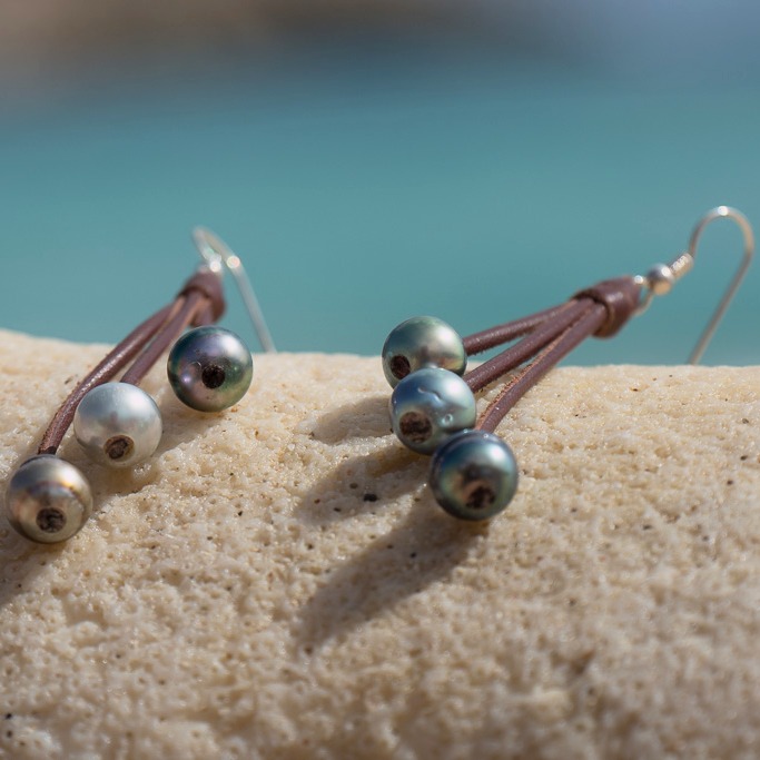 Leather earrings with six Tahitian pearls, in a natural still-life setting