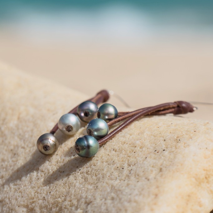 Leather earrings with six Tahitian pearls, in a natural still-life setting