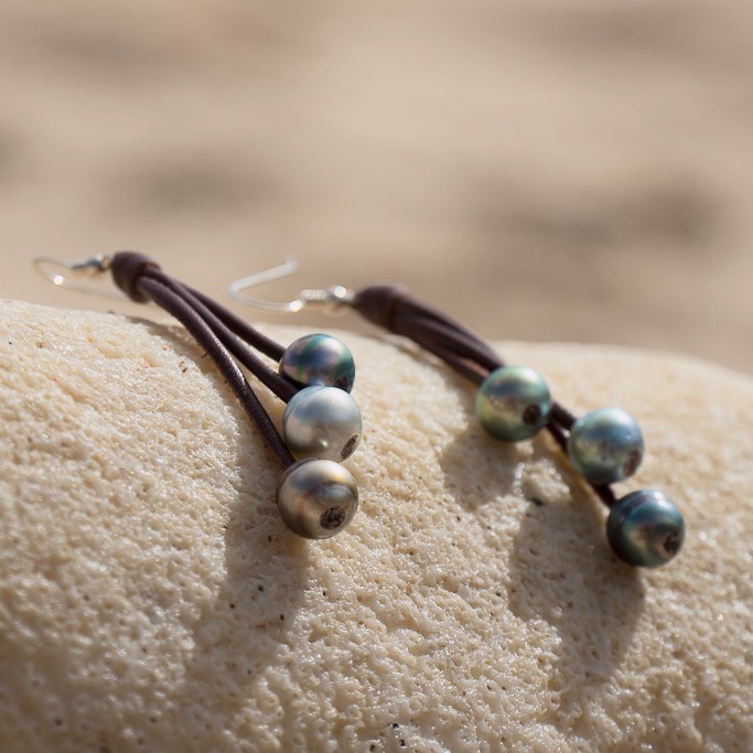 Leather earrings with six Tahitian pearls, in a natural still-life setting
