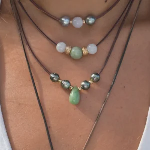 Leather necklace with a jade drop and Tahitian pearls, worn at the neckline