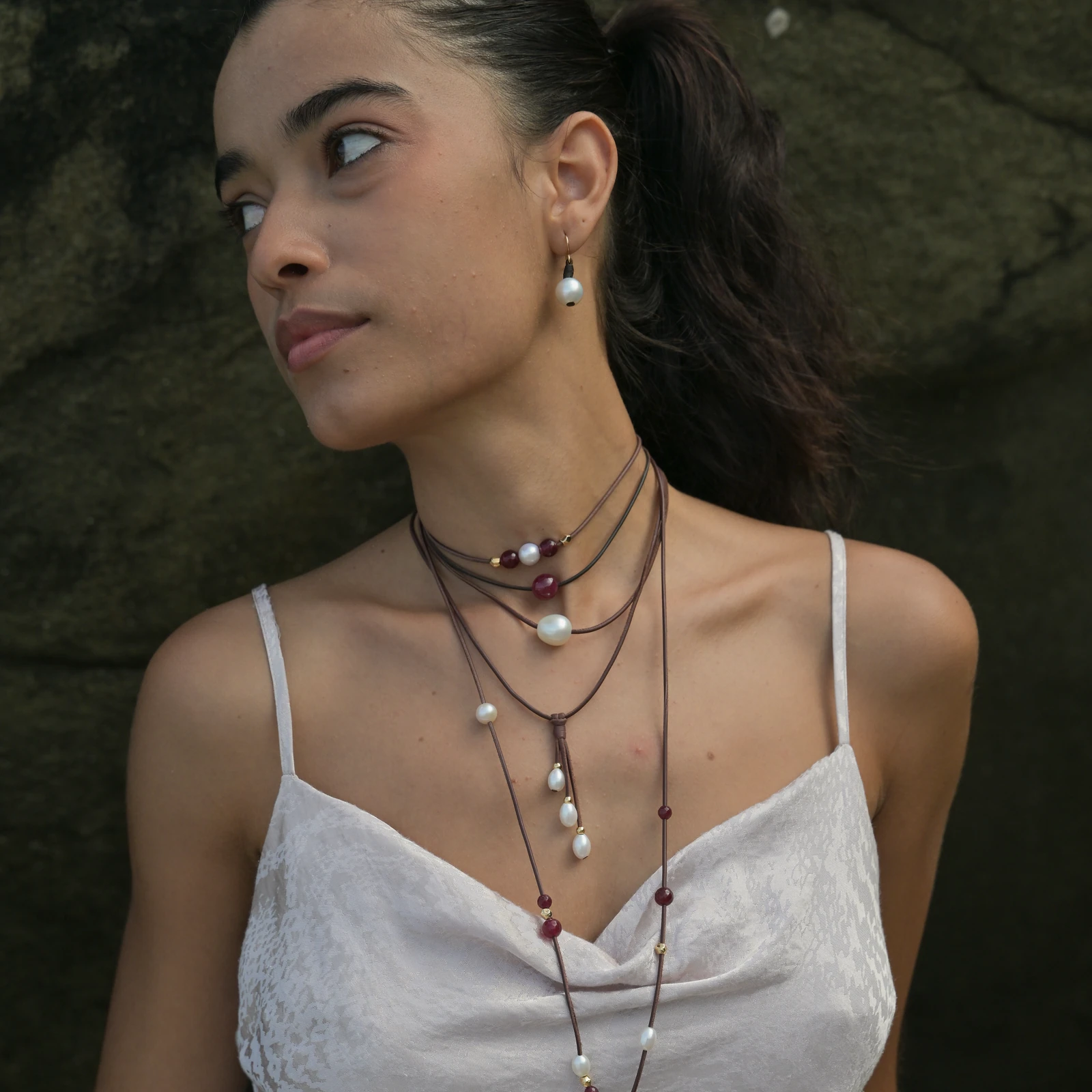 Classic leather earrings with cultured pearls, worn on the ears