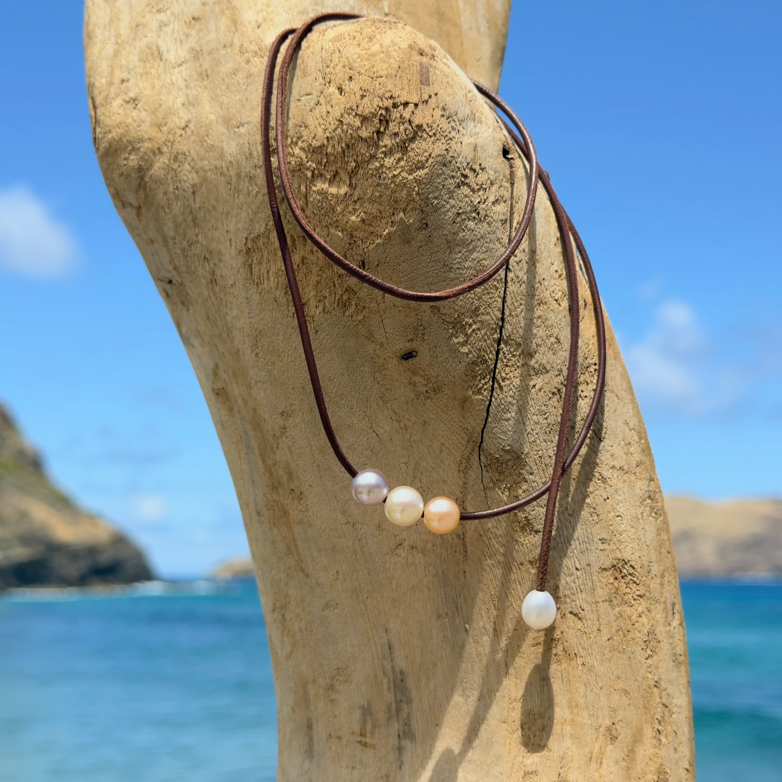 Leather choker with three pastel pearls, on a natural background