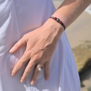Bracelet en cuir, perle de Tahiti entre deux rubis, porté