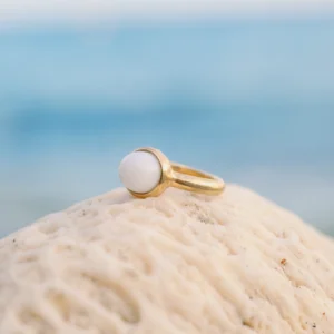 Bague solitaire en or et perle de bénitier, sur fond naturel