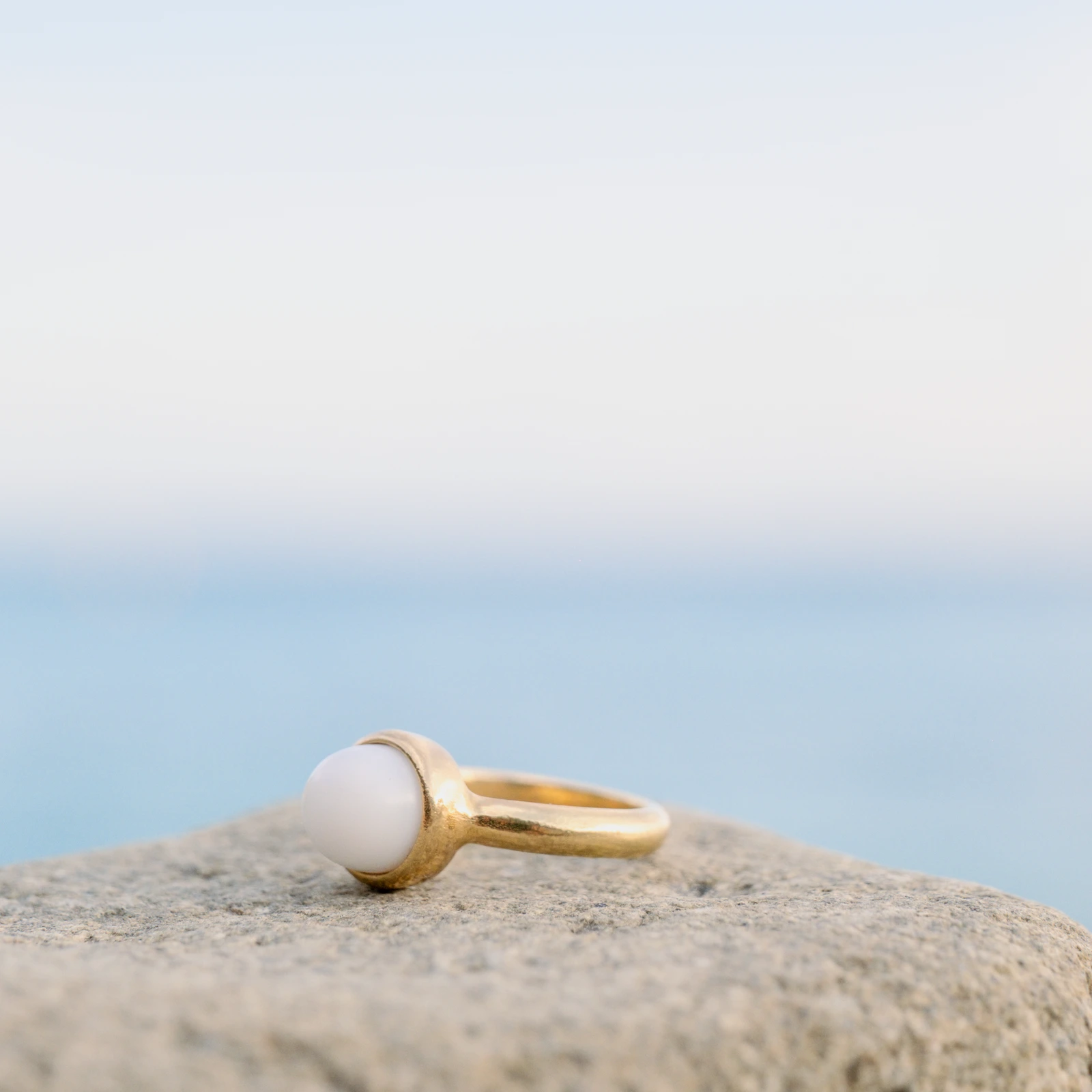 Bague solitaire en or et perle de bénitier, sur fond naturel