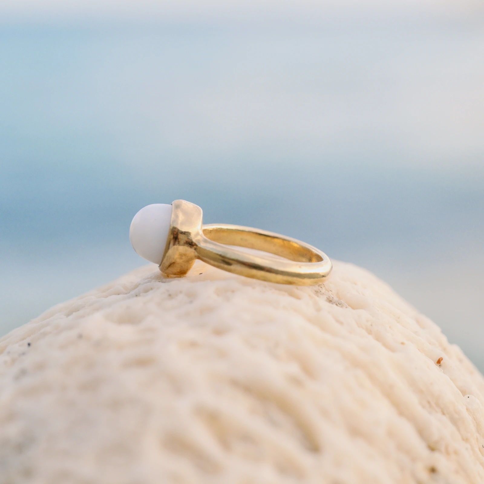 Bague solitaire en or et perle de bénitier, sur fond naturel