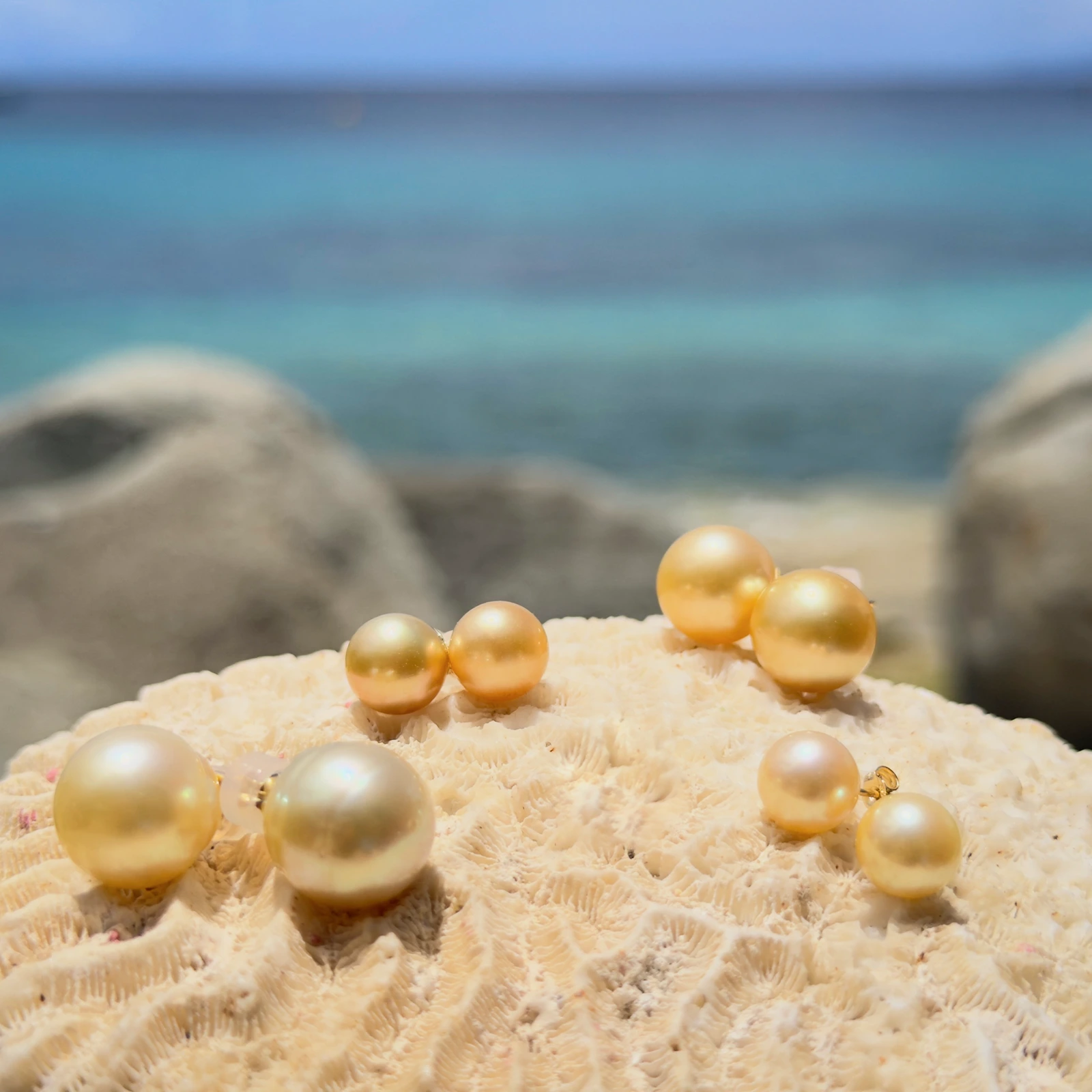 Clous d’oreilles et perles dorées des mers du Sud, sur fond naturel