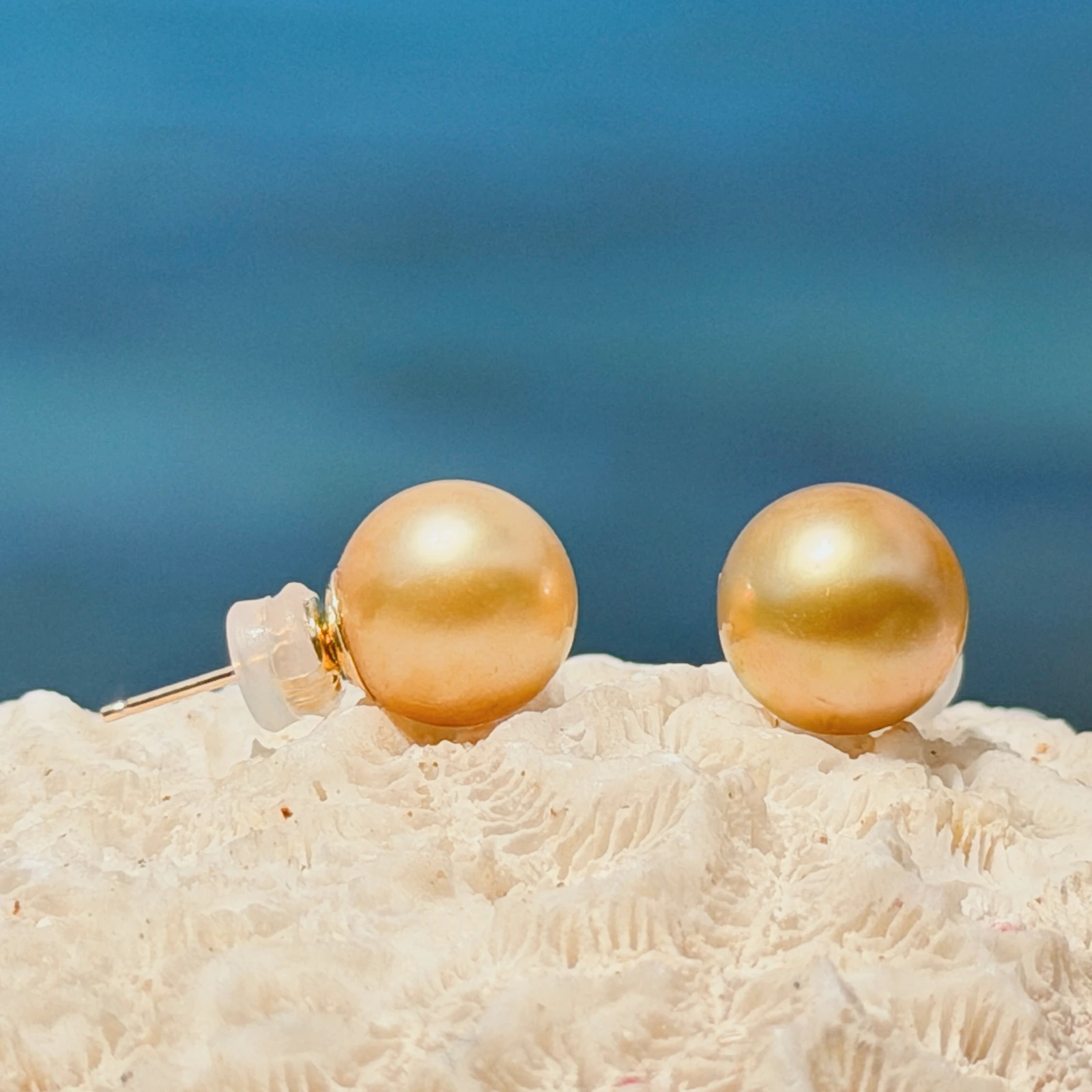 Clous d’oreilles et perles dorées des mers du Sud, sur fond naturel