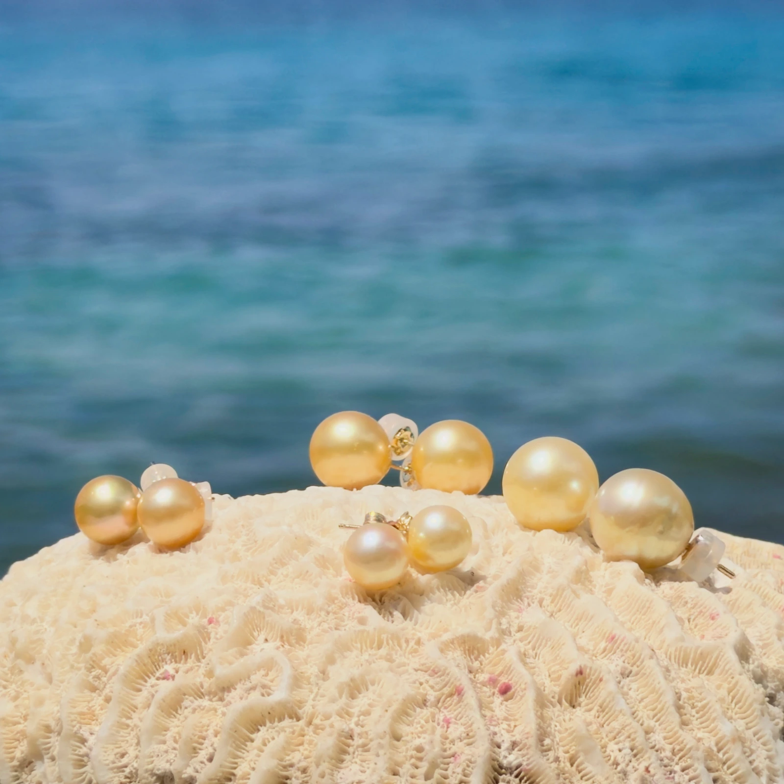 Clous d’oreilles et perles dorées des mers du Sud, sur fond naturel