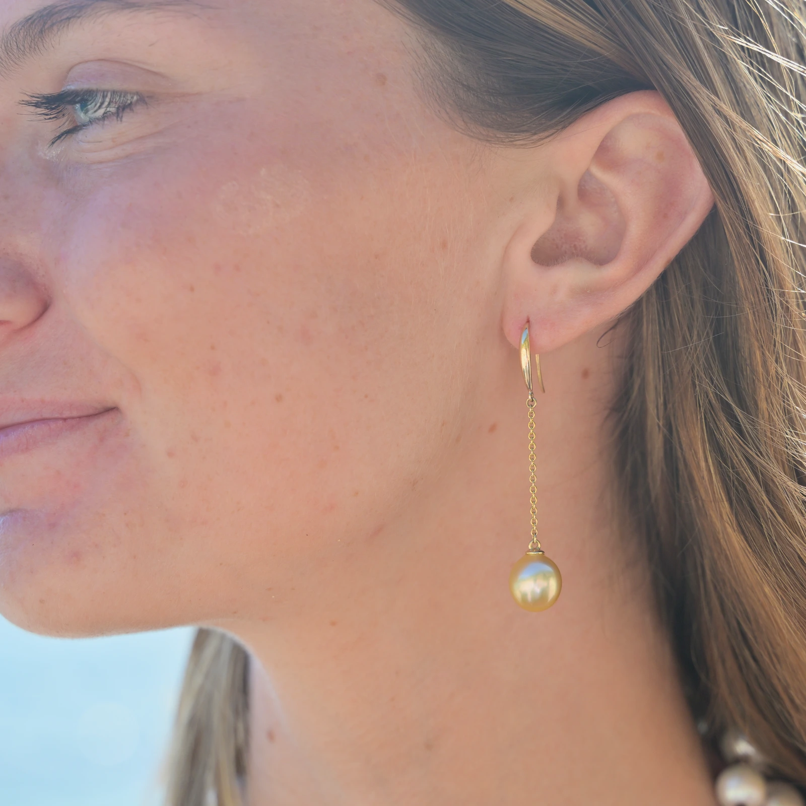 Boucles d’oreilles longues sur dormeuses en or et perles au choix, porté