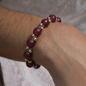 Faceted ruby bracelet with gold-plated beads and a South Sea pearl, worn